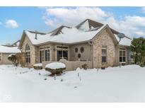 Brick ranch home with snow-covered patio and yard at 4909 Bridgefield Dr, Indianapolis, IN 46254
