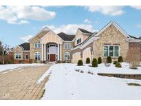 Two-story home with stone and brick exterior, a three-car garage, and a paved driveway at 561 Fairwind, Brownsburg, IN 46112