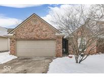 Brick ranch home with attached garage, nestled on a snow-covered lot at 811 Buffalo Run Way, Indianapolis, IN 46227