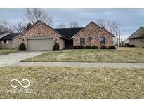 Brick ranch home with attached garage and landscaped lawn at 819 Cypress S, Greenwood, IN 46143