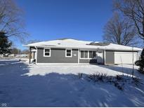 Gray house with white trim, new construction, and snowy yard at 14 E Roberts Rd, Indianapolis, IN 46227