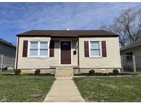 Charming home featuring a well-manicured lawn, vinyl siding, and delightful curb appeal at 1612 E Raymond St, Indianapolis, IN 46203