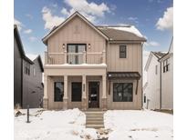 Two-story farmhouse-style home with balcony, brick accents, and snow-covered landscaping at 17363 Newton Main St, Westfield, IN 46074