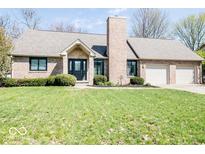 Charming brick home featuring a manicured lawn and attached two car garage at 1966 Broadmoor Ln, Columbus, IN 47203