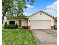 Charming single-story home featuring a well-maintained lawn, attached two-car garage, and inviting front entrance at 5327 Milhouse Rd, Indianapolis, IN 46221