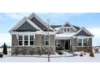 Gray-brick two-story house with a gray roof, stone accents, and a snowy front yard at 953 Indrum Ct, Greenwood, IN 46143