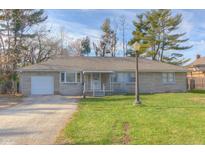 Charming single-story home featuring a stone facade, attached garage, and well-maintained front yard at 2010 N Irwin St, Indianapolis, IN 46219