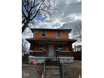 Two-story house with orange and blue siding, brick steps, and a small front yard at 2607 E 12Th St, Indianapolis, IN 46201