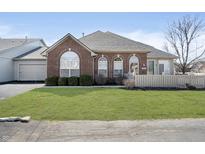 Charming brick home featuring arched windows, a well-manicured lawn, and inviting curb appeal at 2811 Grandview Ln, Greenwood, IN 46143