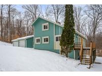 Snow covered home exterior, teal siding, attached garage, deck, and stairs at 3764 Glenwood Dr, Martinsville, IN 46151