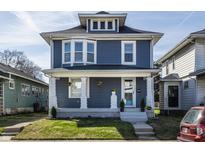 Charming blue two-story home with white trim, inviting front porch and landscaped yard at 404 N Gray St, Indianapolis, IN 46201