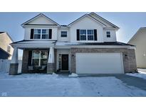 Two-story home with white siding, brick accents, and a two-car garage at 6823 Aster Dr, Pendleton, IN 46064