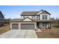 Beautiful two-story home featuring a three-car garage, covered porch, and manicured landscaping at 7414 Glen Park Way, Indianapolis, IN 46259