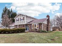 Brick ranch home with attached garage and landscaped yard at 8324 Mann Rd, Indianapolis, IN 46221