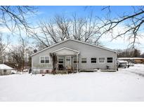 Gray house with a front porch, sitting on a snowy lawn at 13346 N Miller Dr, Camby, IN 46113