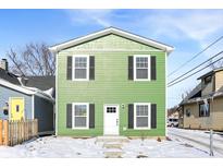 Green two-story house with white trim and black shutters, steps leading to the entrance, and a snowy front yard at 1446 E Naomi St, Indianapolis, IN 46203