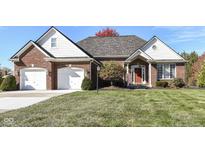 Brick ranch home with two-car garage and lush green lawn at 14580 Adios Pass, Carmel, IN 46032