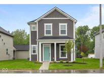 Charming two-story home with gray siding, white trim, and a welcoming turquoise front door at 1713 Real St, Indianapolis, IN 46240