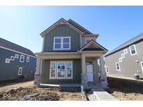 Charming two-story home featuring a modern design, covered entry, and stone accents on the front pillars at 1717 Real St, Indianapolis, IN 46240