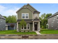 Charming two-story home featuring stone accents, well-kept lawn, and a welcoming front porch at 1717 Real St, Indianapolis, IN 46240