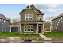 Two-story home showcasing an inviting covered front porch and a well-manicured lawn at 1717 Real St, Indianapolis, IN 46240