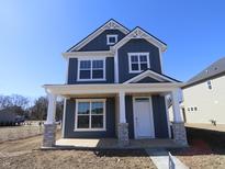 Charming two-story home featuring a welcoming front porch with stylish stone-accented columns at 1721 Real St, Indianapolis, IN 46240