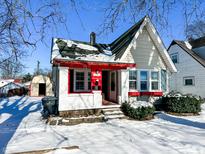 Charming bungalow with red accents and snowy front yard at 244 W 38Th St, Anderson, IN 46013