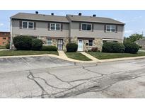 Two-story townhomes featuring stone and siding exteriors and well-maintained landscaping at 2634 Country Estates Dr # 17, Indianapolis, IN 46227