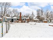 Snowy backyard with a brick home, wooden fence, and various outbuildings at 3206 S Lockburn St, Indianapolis, IN 46221