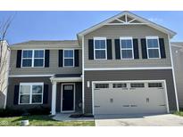 Two-story home featuring a 2-car garage, black shutters, and a landscaped front yard at 371 Traditions Pass, Greenwood, IN 46143