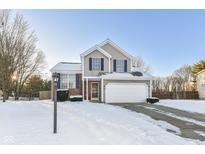 Two-story house with a snow-covered lawn, attached garage, and brick facade at 4842 Rocky Knob Ln, Indianapolis, IN 46254