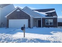 Brick home with attached garage, nestled on a snow-covered lot at 5154 Bramwell Ln, Whitestown, IN 46075
