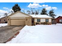 Ranch style home with stone accents and a snow-covered lawn at 5817 Marcia Ln, Indianapolis, IN 46217