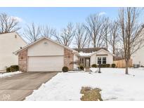Brick ranch home with attached garage and snow-covered yard at 5933 Woodcote Dr, Indianapolis, IN 46221