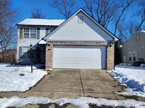 Two-story house with attached garage, snow-covered driveway, and front yard at 5954 Polonius Dr, Indianapolis, IN 46254
