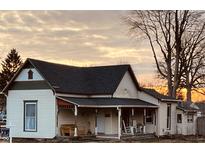 Charming 1-story home with a wrap-around porch and unique architectural details at 704 S Ohio St, Sheridan, IN 46069