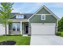 Charming exterior of a two-story home featuring green siding, a two-car garage, and a beautifully landscaped front yard at 9711 Palermo Ave, Indianapolis, IN 46239
