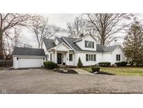White brick home with gray roof, attached garage, and landscaped yard at 1303 Meadowbrook Dr, Indianapolis, IN 46240