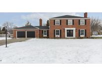 Brick house with 2-car garage and snow-covered lawn at 1716 Westwood Dr, Anderson, IN 46011