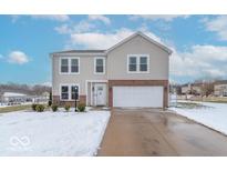 Two-story house with a brick facade, attached garage, and snow-covered landscaping at 507 Abbywood Cir, Danville, IN 46122