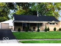 Charming single story home with a well-manicured front yard, large trees, and asphalt driveway at 604 Gooseberry Ln, Greenwood, IN 46143
