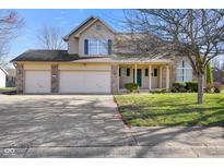 Charming two-story home with a three car garage, covered porch, and a well maintained lawn at 6116 Prairie Stream Way, Columbus, IN 47203