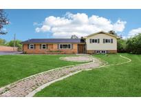 Charming two-story home with a brick and vinyl exterior and a curved brick walkway leading to the entrance at 6327 E 52Nd Pl, Indianapolis, IN 46226