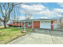 Brick ranch home with attached garage and well-maintained lawn at 701 W 7Th St, Greenfield, IN 46140