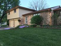 Ranch style home with brick and siding exterior, copper gutters, and landscaped lawn at 707 Spring Valley Ct, Indianapolis, IN 46231
