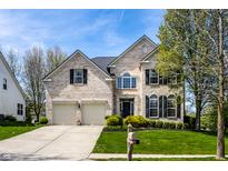 Traditional two-story brick home featuring an attached two-car garage and well-manicured front lawn at 12596 Autumn Gate Way, Carmel, IN 46033