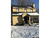 Cute yellow house with snow covered yard at 2615 Baltimore Ave, Indianapolis, IN 46218