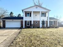 Traditional two-story home featuring a symmetrical facade, white siding, brick accents, and a two-car garage at 3015 Olive Branch Rd, Greenwood, IN 46143