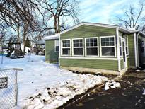 Green house exterior with sunroom and snowy yard at 3153 N Layman Ave, Indianapolis, IN 46218