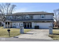 Two-story house needing repairs, featuring a large driveway and attached garage at 4349 Alhambra Dr, Anderson, IN 46013
